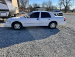 2008 Grand Marquis LS parked on gravel, showcasing its white exterior and clean design.