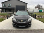 Front view of a 2015 Chevrolet Traverse LT AWD parked in a driveway, ready for winter with good tires.