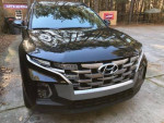 Front view of a black 2022 Hyundai Santa Cruz SEL AWD parked outdoors, showcasing its sleek design.