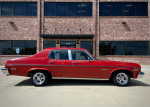1973 Chevrolet Nova Custom Sedan, red color, parked in front of a brick building, great condition, available for cash or trade.