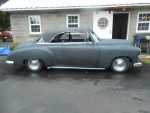 1950 Chevrolet 2-door hardtop with updates, parked outdoors near a garage.