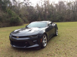 2016 Chevrolet Camaro SS in Midnight Charcoal Metallic Gray, excellent condition, parked on grass, showcasing stylish design.