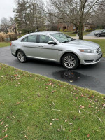 2013 Ford Taurus Limited in silver parked on driveway, showing exterior and surrounding lawn.