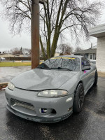 1995 Mitsubishi Eclipse GST with aftermarket parts, showcasing performance features and sleek design.