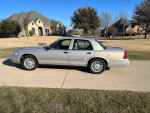 2008 Mercury Grand Marquis LS in silver, low mileage, parked in front of residential homes