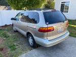 2000 Toyota Sienna XLE minivan parked in a driveway, showcasing its clean exterior and family-friendly design.