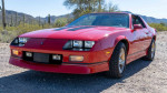 1988 Chevrolet Camaro IROC in red with a 5-speed manual transmission and 5.0L V8 engine, showcasing classic design.