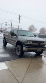 2000 Chevrolet Silverado 1500 in the snow, featuring a 4-inch lift and aftermarket modifications.