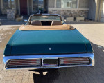 Rear view of a 1972 Mercury Cougar XR7 Convertible with a green exterior and light tan convertible top.