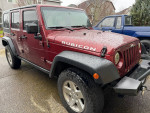 2008 Jeep Wrangler Rubicon 4WD in dark red, featuring clean body and newer black rims, parked in residential area.