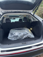 Interior view of a 2016 Ford Edge Titanium trunk area with a spare tire covered in plastic.