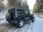 2009 Jeep Wrangler Rubicon 4WD parked on snowy terrain, showcasing rugged design and well-maintained condition.
