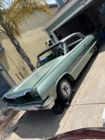 1964 Chevrolet Impala project car parked in driveway, showcasing its clean body and chrome detailing.