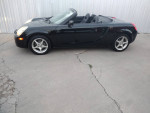 Side view of a 2003 Toyota MR2 Spyder convertible with 100,300 original miles, showcasing its sleek design.