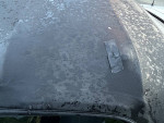 Upper view of a Mazda Miata soft-top showing wear and a patch on the roof.