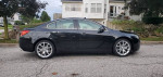 Side view of a black 2013 Buick Regal GS on a street, showcasing its sleek design and alloy wheels.
