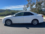 2013 Toyota Camry XLE in excellent condition, white exterior, side view with tinted windows and alloy wheels.