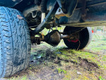 Underneath view of a 1989 Chevy Suburban showcasing 2500 axles and wheels on a grassy surface.
