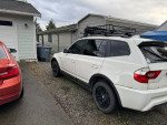 2006 BMW X3 parked in driveway, showcasing its rugged exterior and roof rack.
