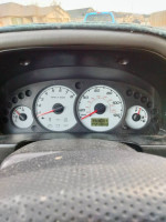 2002 Ford Escape dashboard showing speedometer and RPM gauge at 100,000 miles in a well-used vehicle.