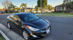 2013 Hyundai Elantra Limited sedan parked on street, showcasing exterior and clean body with minor dent.