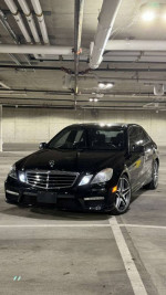 2010 Mercedes-Benz E 63 AMG parked in a garage with clean, sporty design and alloy wheels.