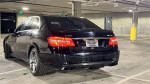 2010 Mercedes-Benz E63 AMG black car parked, showing rear view and sleek design features.