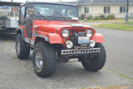 1974 Jeep CJ5 with aftermarket modifications, lifted suspension, and off-road tires parked on a street