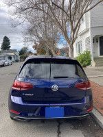 Rear view of a 2019 Volkswagen e-Golf in Atlantic Blue, parked on a residential street.