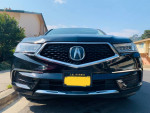 Front view of a 2018 Acura MDX Sport Hybrid SUV with a sleek black finish and modern design.