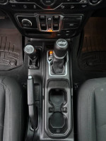 Interior view of 2019 Jeep Wrangler Sport showing gear shifter and control panel features