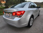 2014 Chevrolet Cruze LS in silver with a clean design parked on a street, showcasing its rear view.