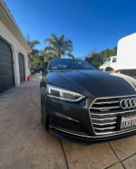 Front view of a 2015 Audi A5 in grey with a sleek design, parked in a driveway.