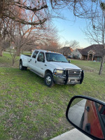 2004 Ford F350 Super Duty 4x4 Dually parked on grass, featuring leather seats and sunroof, low mileage.