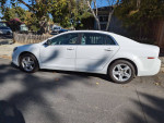 2012 Chevrolet Malibu LS FWD in white parked on the street with normal wear and tear.
