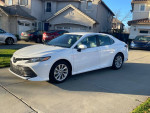 2021 Toyota Camry in pristine condition with 6,000 miles, parked outside a residential area.