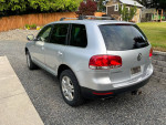 2005 Volkswagen Touareg V8 AWD in silver parked on gravel, suitable for winter driving and outdoor activities.