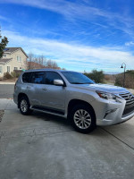 Silver Lexus GX 460 Luxury Edition parked in driveway with clear blue sky