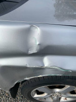 Damaged side of a well-maintained Subaru Impreza with body repair needs and all-weather tires.