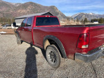 2012 Ram 2500 Power Wagon 4WD parked outdoors with gravel, showcasing its red color and rugged design.