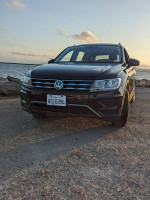 Front view of a 2018 Volkswagen Tiguan parked by the water, showcasing its sleek design and alloy wheels.