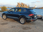 2018 Volkswagen Tiguan parked by the water, showcasing its sleek design and alloy wheels.