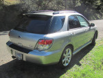 2006 Subaru WRX wagon parked on a scenic road, showcasing its sleek design and sporty rear view.