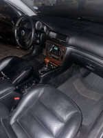 Interior view of a 2002 Volkswagen Passat GLX with black leather seats and wood trim, showing dashboard and controls.