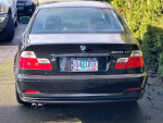 Back view of a 2002 BMW 325ci Coupe in good condition with visible maintenance records.