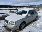 2002 Hyundai Elantra in snowy landscape, showing manual transmission and recently repaired features.