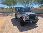1994 Land Rover Defender 110 in great condition with upgraded features, parked in a sunny outdoor setting.