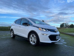 2019 Chevrolet Bolt EV electric car parked on a scenic road, showcasing its compact design and modern features