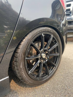 Close-up of a black alloy wheel on a 2010 Mazdaspeed3 with new tires and sleek design.