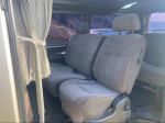 Interior seating of 1994 Toyota Hiace SuperCustom van with patterned fabric and curtains